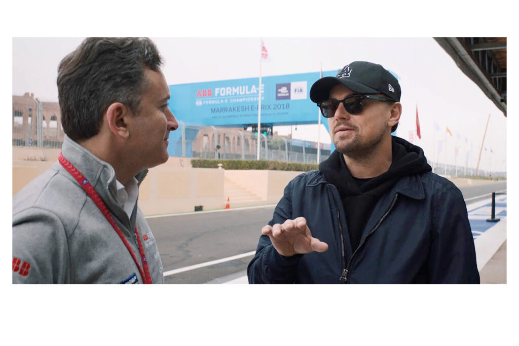 Photo shows Leonardo DiCaprio speaking with Alejandro Agag for the documentary "And We Go Green."