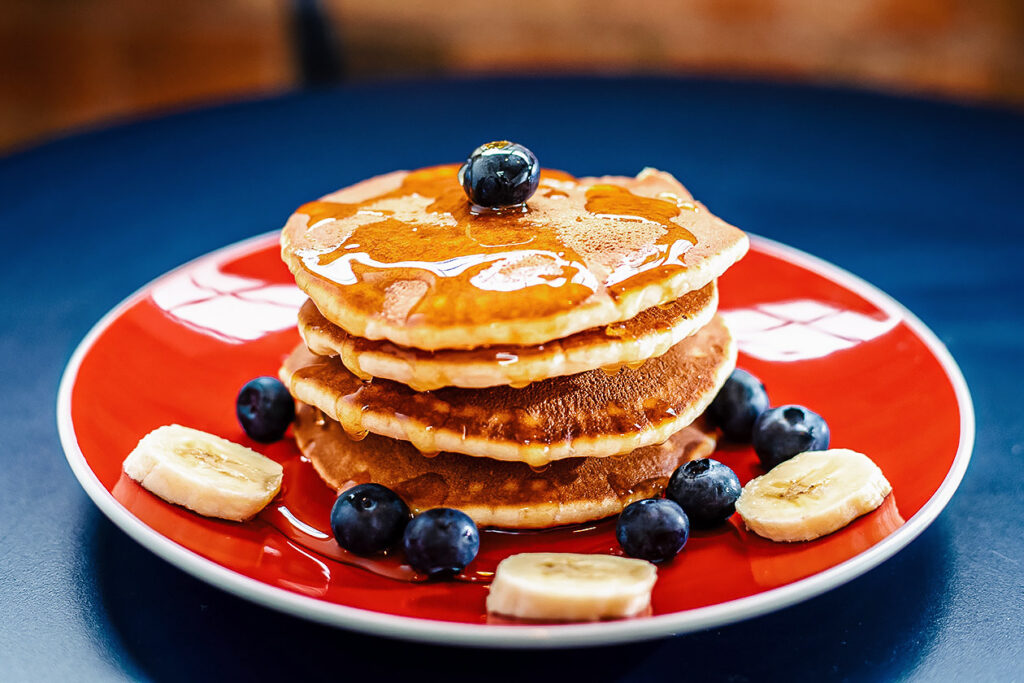 Photo of pancakes with syrup, blueberries, and banana. Patriots lineman Lawrence Guy is going vegan bit by bit, and enjoys pancakes for breakfast.