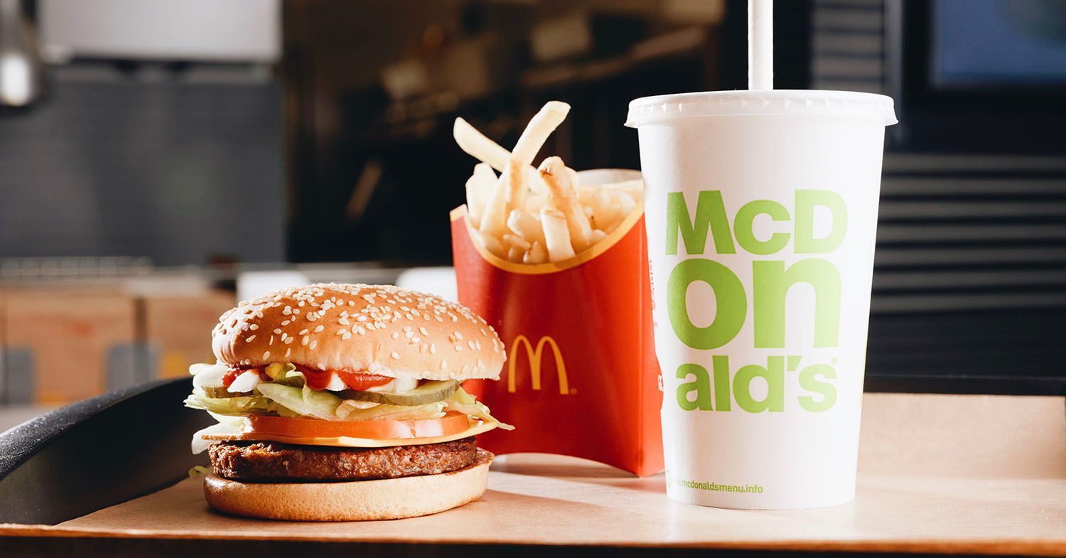 The McDonald's vegan Mcplant burger shown with chips and a drink.