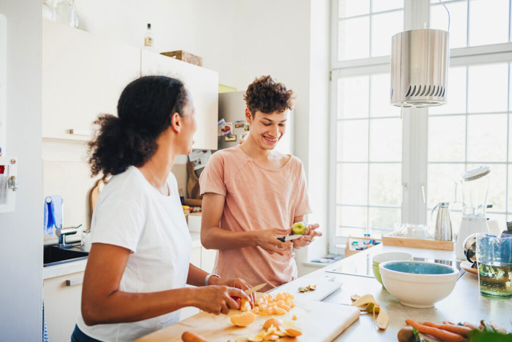 Photo shows two people preparing food at home.