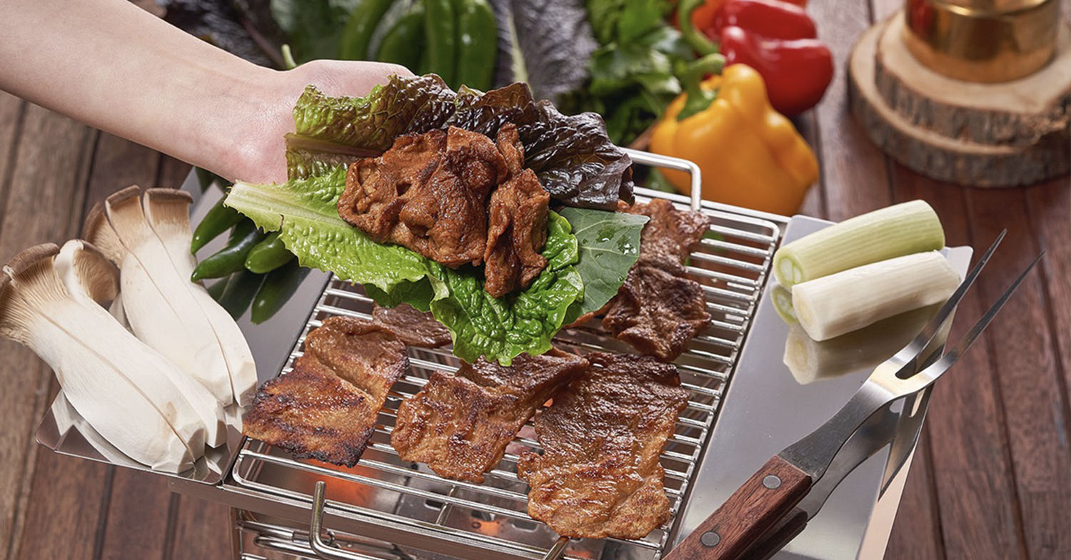 Photo shows South Korean company Zikooin's vegan Unlimeat on a BBQ grill and topping a lettuce leaf.