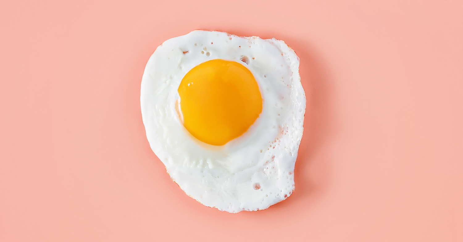 Photo shows a fried egg on a pale pink background. The Every Company is using fermentation to make hyper-realistic egg products.