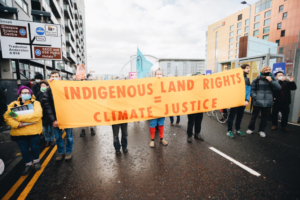 Photo shows a protest by Extinction Rebellion. Activists are marching in Glasgow holding a banner that reads: "Indigenous land rights = climate justice." After the conclusion of the event, some of the most striking images are from demonstrations and protests that took place during COP26.