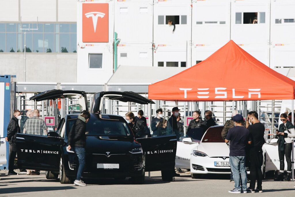 A Tesla next to an orange Tesla stand