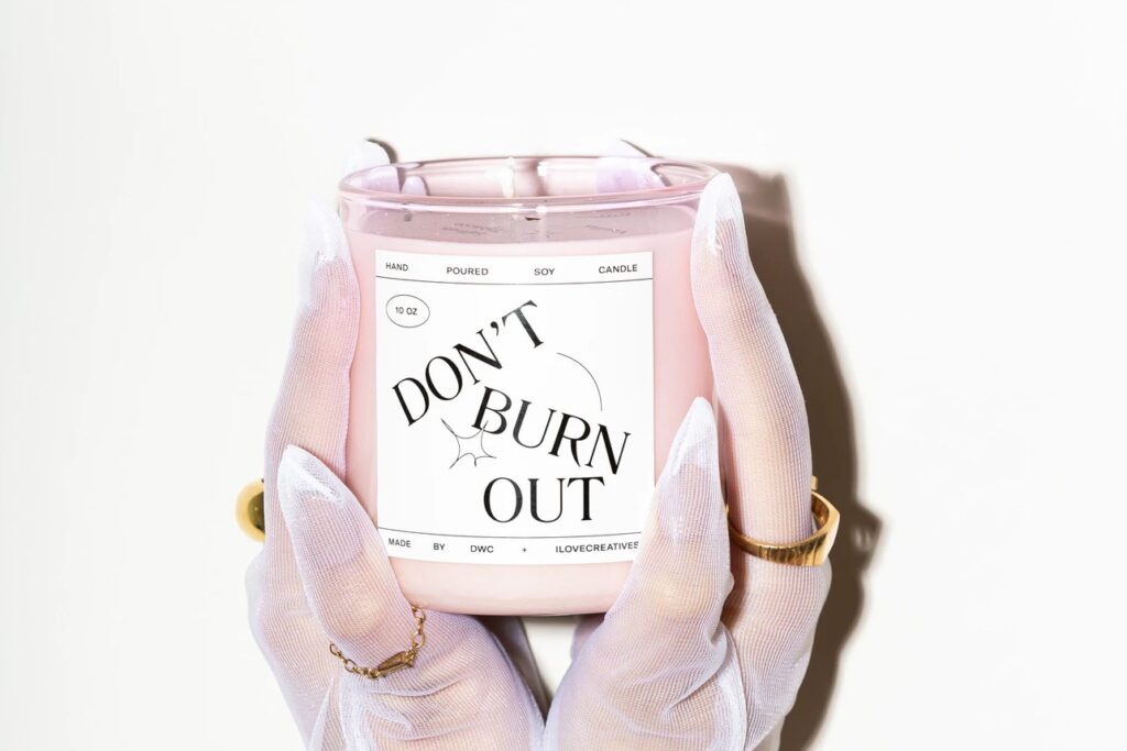 Photo shows gloved hands holding up a "don't burn out" themed candle.