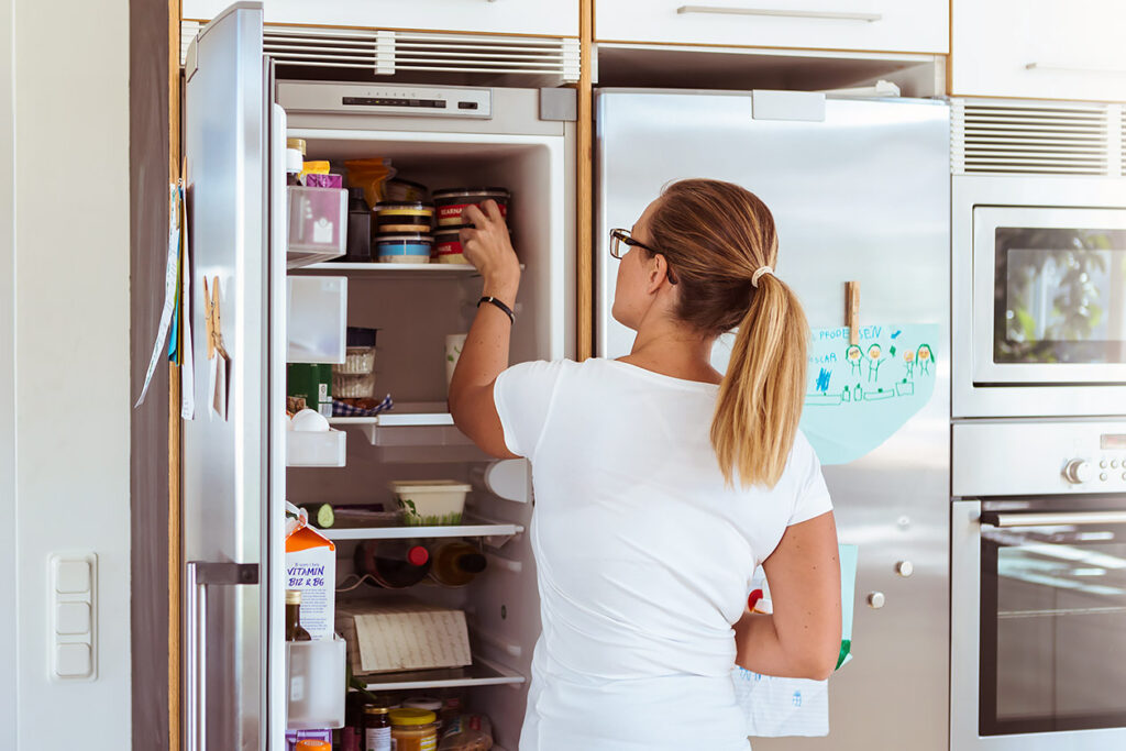 woman getting food out of fridge