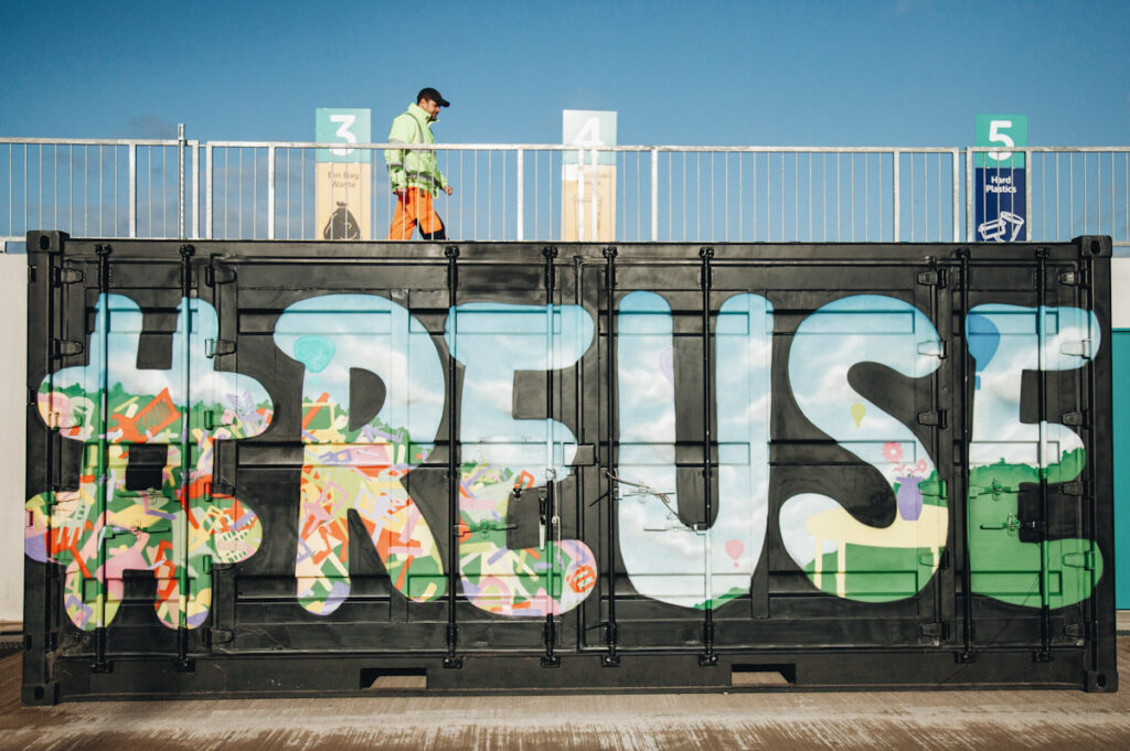 Photo shows a shipping container with "reuse" spray painted on the side.