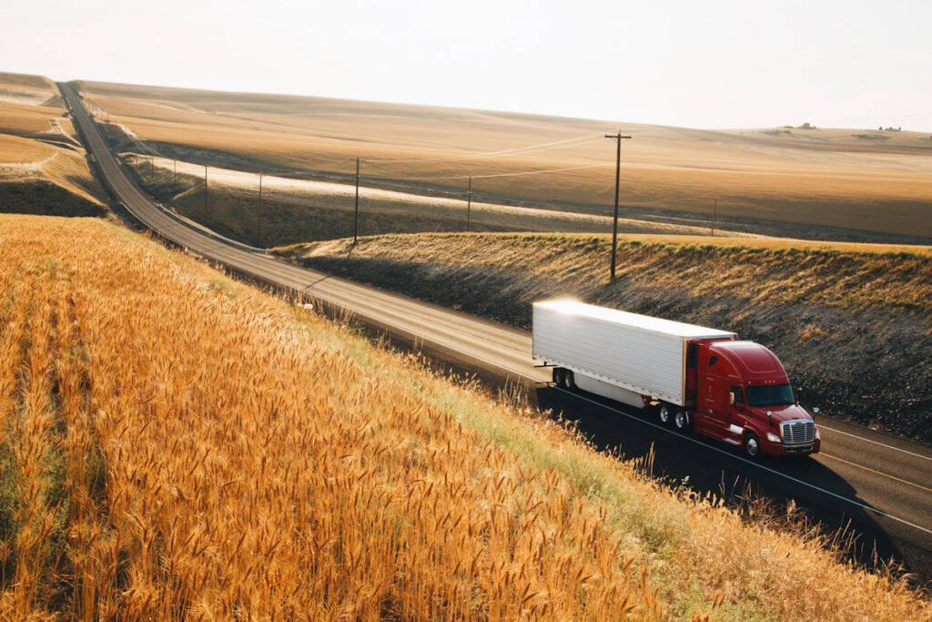 Photo shows a truck driving on a long road between fields that stretch out for miles in the background. New Jersey's environmental law could force the phasing out of diesel trucks as early as 2022 in order to meet a 2025 deadline.