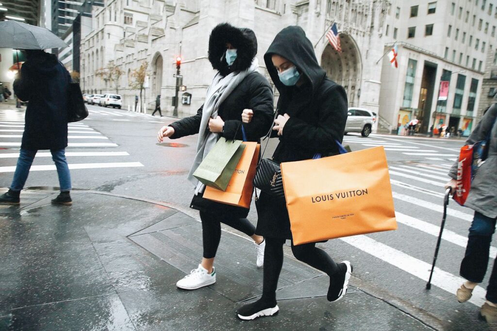 two women walk along with shopping bags in New York
