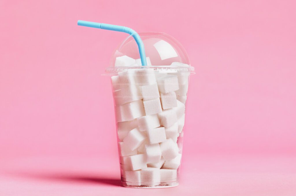 Photo shows a cup full of sugar cubes, a visual and artistic representation of the quantity of sugar contained in typical fizzy drinks.